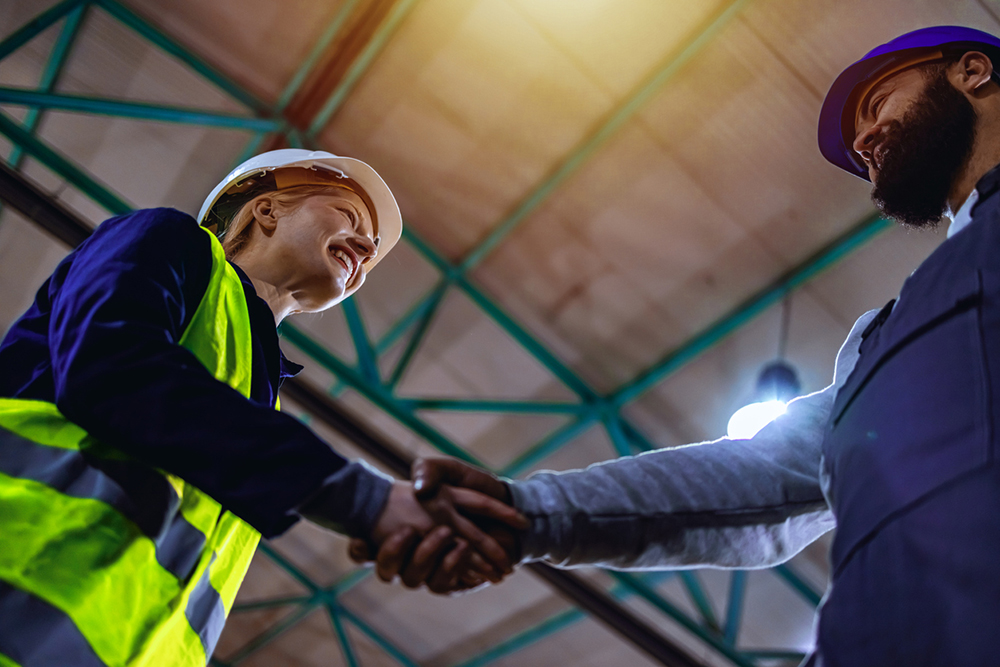 Construction workers shaking hands on demolition project