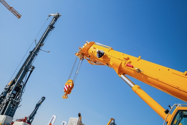 Telescopic crane lifting heavy equipment during a rigging project in NJ & NY
